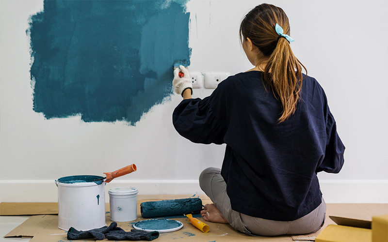 Woman painting her home walls